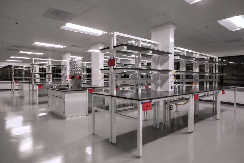 Spacious, modern laboratory with empty workbenches and bright overhead lighting.