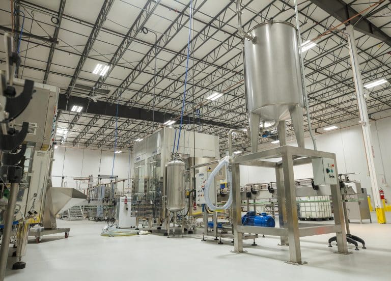 Modern industrial facility with stainless steel equipment and automated conveyor systems.