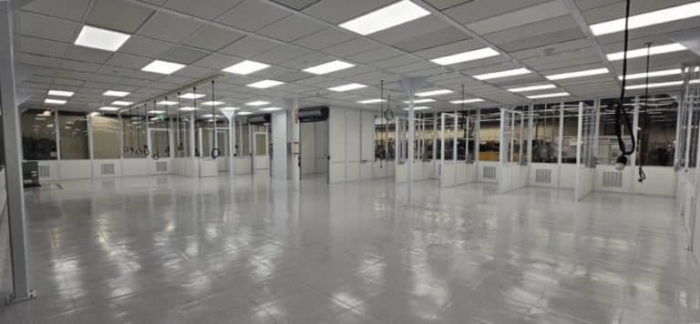 Large, empty, well-lit industrial cleanroom with glass walls and ceiling lights.