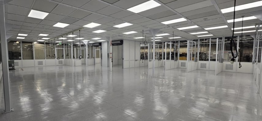 Large, empty, well-lit industrial cleanroom with glass walls and ceiling lights.